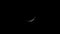 Crescent moon moving through clouds in night sky