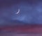 Crescent moon over the cloudy sky at sunset next to Venus