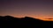 Crescent moon and sunset over silhouette of desert ridge on fall evening