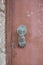 Crete door knocker brass hand hanging down oxidised green on metal brown door