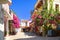 CRETE ISLAND, GREECE, SEP 06, 2012: View on Panormo small city street with bakery restaurant cafe red flowers small hotel for tour