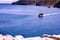 Crete or Kreta, Greece: A ship sailing in a distance on mediterranean sea against rocky terrain on Spinalonga island, formerly