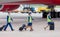 Crew of airplane in dark blue uniform going to board to plane. Plane`s engine and chassis on background. Crew of plane.
