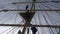 Crew members of Sailing Tall Ship climbing the mast in back light to enter the yards and prepare the sails in late afternoon