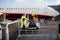 Crew Working At Luggage Conveyor Attached To Airplane