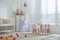 Crib, table and chairs with bunny ears in stylish baby room interior