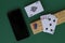 Cribbage wooden games.playing card and cribbage board with black phone on the green