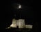 Criccieth castle floodlit at night under a half moon in Criccieth, Gwnydd, Wales