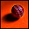 Cricket leather ball isolated in orange background