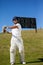 Cricket player swinging bat while standing at field