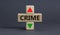 Crime rate symbol. A wooden cubes with up arrow. Wooden block with the concept word Crime. Beautiful grey table grey background.