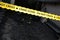 Crime scene tape for covering the area cordon. Yellow tape with blurred forensic law enforcement background in cinematic tone