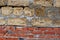 Crimean coquina rock blocks with cement lines on red bricks, wall of two different materials, close up texture