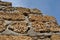 Crimean coquina rock blocks with cement ruined farm wall close up texture, blue sky