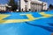 Crimean Tatar flag. Crimea is Ukraine. Patriot People hold large blue flag with yellow tanga emblem near Ukrainian parliament.