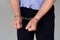 Criminal caucasian hands locked in handcuffs. Closeup view