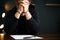 Criminal in handcuffs with confession at desk indoors