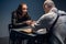 The criminal in handcuffs on hands sits at a table in a police station during interrogation