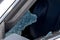 Criminal incident. Hacking a car. Broken driver`s side window of car. Thieves smashed window of car with fragments inside, glass