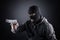 Criminal wearing black balaclava and hoodie with a gun