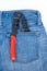 Crimping tool for a laying cable is lying in the rear pocket of blue jeans