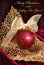 Crimson christmas bauble on golden openwork leaf