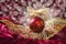 Crimson christmas bauble on openwork golden leaf