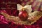 Crimson christmas bauble on openwork golden leaf