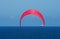 CRIMSON KITE SURFER SAIL ALOFT ABOVE THE OCEAN WITH SHIP IN BACKGROUND