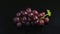 Crimson Splendor: A Stunning Display of Dark Red Grapes on an Enigmatic Black Setting