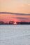 Crimson Sunset over Snowy American Corn Fields in Winter with Bl