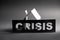 Crisis sign with cut out letters in front of cardboard house shape