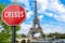 Crisis stop sign with view of Eiffel tower in Paris, France. Financial crash in world economy because of coronavirus pandemic.