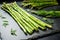 crisp asparagus spears laid side-by-side on a slate tile