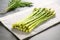 crisp asparagus spears lying on a smooth stone slab