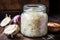 crisp macro shot of sauerkraut strands in a jar, lid off