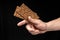 Crisp whole grain breads in the male hand on black background