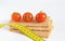 Crispbread and tomatoes with measuring tape on a light background with copy space. Diet and healthy eating.