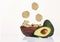 Crispy avocado chips on wooden bowl with fresh avocado fruit on white background