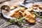 Crispy bake rolls baked on the metal rustic baking pan and served in the paper with rosemary tied by flax twine