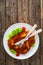 Crispy breaded fried pork chop and fresh vegetables on wooden table