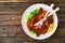 Crispy breaded fried pork chop and fresh vegetables on wooden table