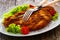 Crispy breaded fried pork chop and fresh vegetables on wooden table