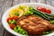 Crispy breaded fried pork chop, green asparagus and fresh vegetables on wooden table