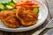 Crispy breaded fried pork loin chops with sweet potato fries and boiled Brussels sprouts on wooden table