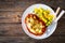 Crispy breaded seared pork chop with fried white mushrooms, cheese and boiled potatoes on wooden table