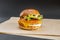 Crispy chicken burger with mayonnaise, cheddar cheese, tomato and lettuce on shiny bread