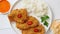 Crispy chicken fried in breadcrumbs served with rice. View from the top on white wooden background