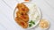 Crispy chicken fried in breadcrumbs served with rice. View from the top on white wooden background