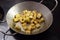 Crispy croutons fried with herbs in a pan on the dark stove, coo